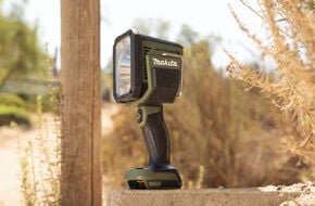 Makita Outdoor Adventure green flashlight on ledge near pole