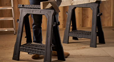 Two stanley sawhorses holding a piece of wood
